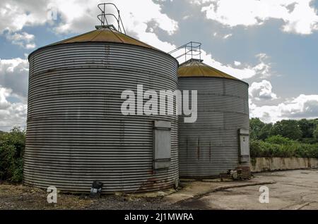 Deux silos utilisés pour stocker le grain et se nourrir dans une ferme de Basingstoke, dans le Hampshire, lors d'une journée ensoleillée d'été. Banque D'Images