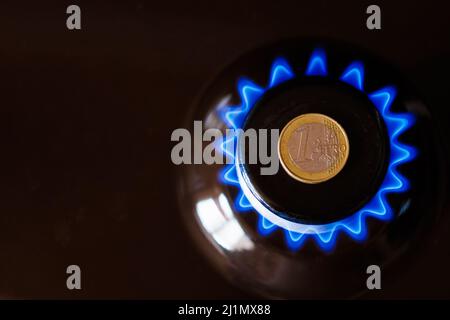 brûleur à gaz avec une pièce d'un euro posée sur le dessus, brûlant du gaz naturel avec une flamme bleue Banque D'Images