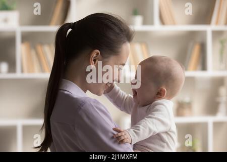 Bonne mère aimante tenant sur les mains bébé doux. Banque D'Images