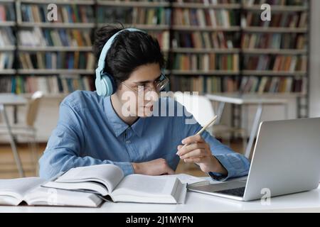 Les élèves font du travail scolaire dans la bibliothèque, font parler videocall à un tuteur Banque D'Images