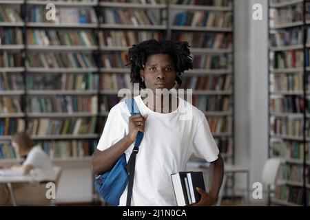Un étudiant africain sérieux pose dans la bibliothèque du campus Banque D'Images