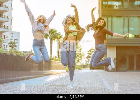 heureux belle trois femmes sautant en plein air, jeunes femmes insouciantes amis célébrant la victoire levant les bras, le bonheur et le concept réussi Banque D'Images