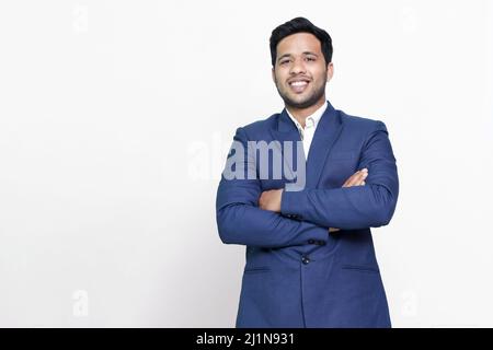 Jeune homme d'affaires hispanique aux bras croisés souriant heureux. Banque D'Images