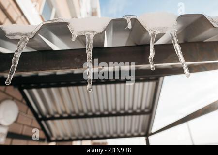 les glaçons fondent sur le toit au printemps Banque D'Images