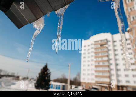 les glaçons fondent sur le toit au printemps Banque D'Images