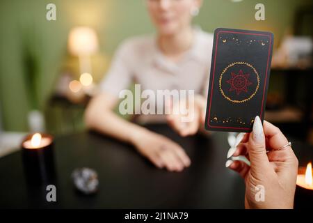 Gros plan d'une femme au palmarès montrant des cartes de tarot pour une jeune femme qui visite à la séance spirituelle, espace de copie Banque D'Images