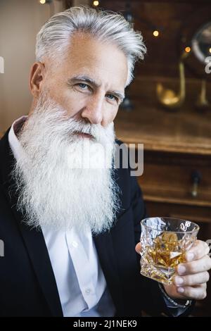 Beau barbu homme âgé avec un verre de whisky Banque D'Images