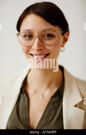 Portrait vertical des jeunes femmes entrepreneures qui portent des lunettes et sourient à l'appareil photo Banque D'Images