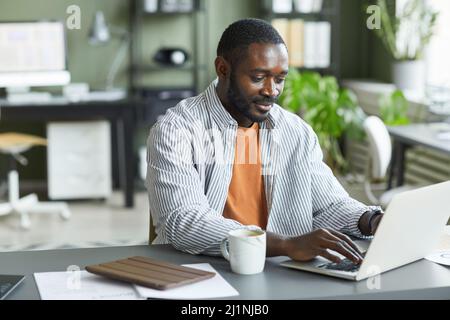 Portrait d'un homme noir adulte travaillant au bureau à domicile et utilisant un ordinateur portable, espace de copie Banque D'Images