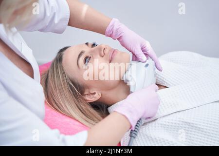 Patient féminin soumis à une procédure non chirurgicale de serrage de la peau Banque D'Images