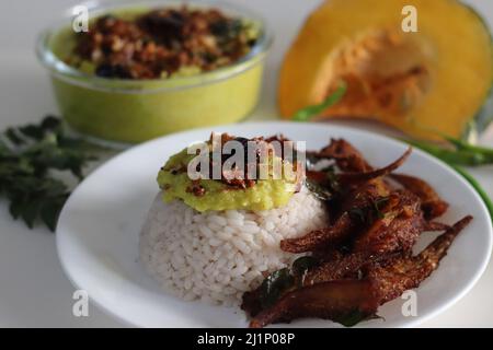 Repas au Kerala avec riz rouge mata bouilli, curry de citrouille à base de noix de coco et frites anchois. Prise de vue sur fond blanc Banque D'Images