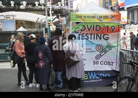 Les gens se rassemblent autour d'un site de test rapide Covid-19 sur 42nd Street à Manhattan. Banque D'Images