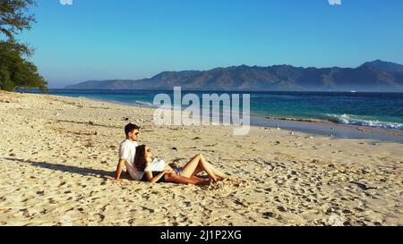 Un couple caucasien couché ensemble et appréciant la vue sur la plage de Gili Meno, Indonésie Banque D'Images