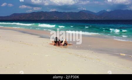 Un couple caucasien se trouvant sur la plage et appréciant la vue panoramique à Gili Meno, Lombok, Indonésie Banque D'Images