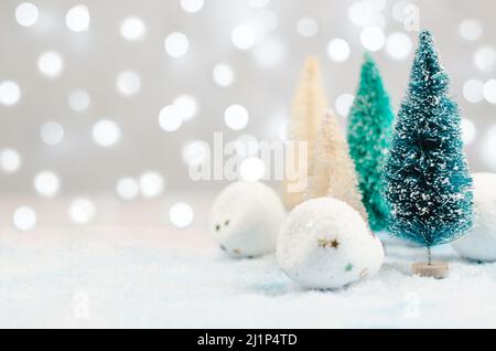 Arrière-plan de Noël avec arbres, neige et boules de neige sur un fond de lumières floues. Décoration de Noël sur fond de lumières bokeh, espace de copie Banque D'Images