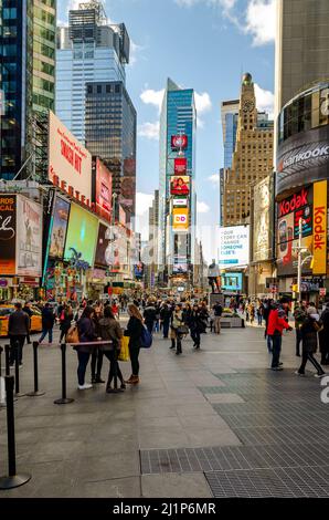 Il y a beaucoup de monde à Time Square New York City avec beaucoup de gens debout et marchant le soir, Skyscraper avec publicité, vertical Banque D'Images