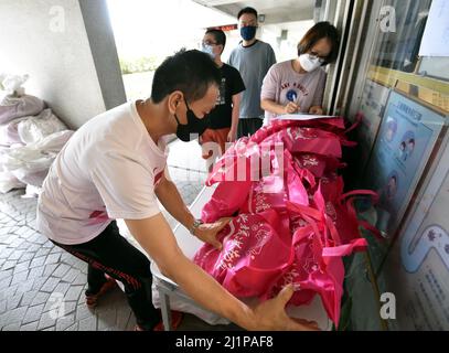 Hong Kong, Chine. 27th mars 2022. Le personnel distribue des fournitures de lutte contre les épidémies aux résidents de Hong Kong, dans le sud de la Chine, le 27 mars 2022. Dimanche, Hong Kong a enregistré 3 555 nouveaux cas de COVID-19 par des tests d'acide nucléique, et 4 482 autres cas positifs par des tests d'antigène rapides auto-déclarés, ont montré des données officielles. Crédit : Lo Ping Fai/Xinhua/Alamy Live News Banque D'Images