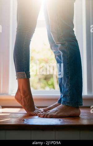 Atteindre un baiser. Photo courte d'un couple méconnu qui embrasse à la maison. Banque D'Images