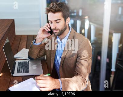 Il sait faire les choses. Photo d'un jeune entrepreneur parlant au téléphone dans un café. Banque D'Images
