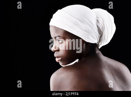 Sa beauté parle d'elle-même. Photo studio d'une belle femme portant un foulard sur fond noir. Banque D'Images