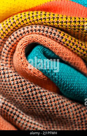 Plis torsadés de tissus tricotés colorés de vêtements d'hiver avec différentes structures et textures. Lisser l'arrière-plan des formes. Multi-colo plié lisse Banque D'Images
