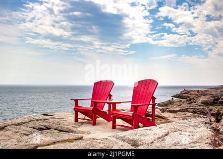 Adirondack chaises rouges près de Tadoussac, Québec, Canada pour observer les baleines dans le fleuve Saint-Laurent Banque D'Images