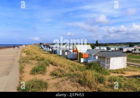 Huttes de plage en bois sur le front de mer derrière les dunes de sable à Heacham North Beach, un village côtier à l'ouest de Norfolk, Angleterre, surplombant le Wash Banque D'Images