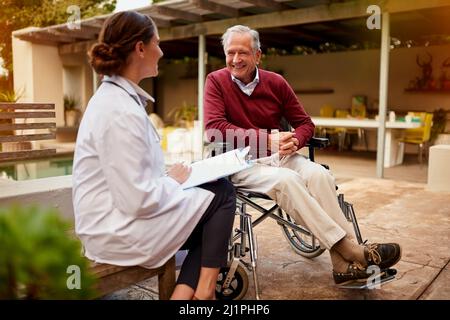 C'est une excellente nouvelle, doc. Prise de vue d'un jeune médecin et de sa patiente âgée parlant en étant assise à l'extérieur. Banque D'Images