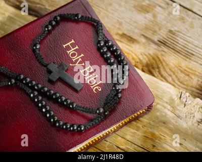 Un rosaire avec une croix catholique et une Sainte Bible se trouve sur une table en bois. Prière, spiritualité, foi, catholicisme. Sainte communion. Il n'y a personne dans Th Banque D'Images