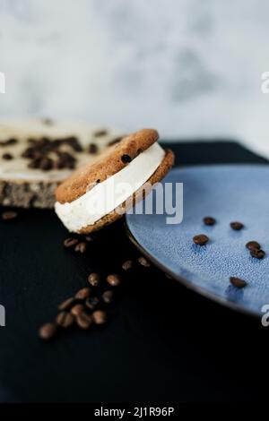 Sandwich à la crème glacée. Glace à la vanille coincée entre deux biscuits aux chips et des grains de café Banque D'Images