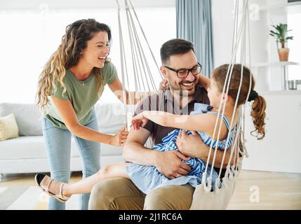 enfant fille famille heureuse mère père canapé jouer ensemble amusant fille souriante maison intérieure Banque D'Images