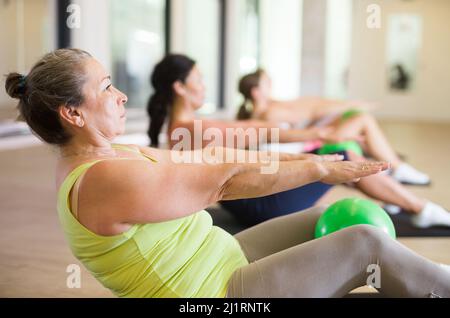 Aérobic pilate les femmes avec des balles de toning dans la rangée sur le cours de fitness Banque D'Images