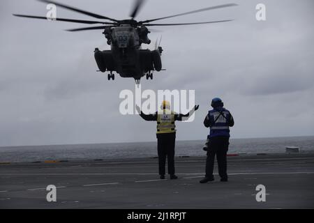 Un marin de la Royal Navy britannique signale un atterrissage à un Super Stallion CH-53E pendant l'exercice Cold Response 2022, Mer norvégienne, 24 mars 2022. Le CH-53E Super Stallion est affecté au Marine Heavy Helicopter Squadron (HMH) 366, Marine Aircraft Group 29, 2D Marine Aircraft Wing. L'exercice Cold Response '22 est un exercice biennal de préparation nationale et de défense norvégien qui a lieu dans toute la Norvège, avec la participation de chacun de ses services militaires, ainsi que de 26 autres nations alliées de l'OTAN et partenaires régionaux. (É.-U. Photo du corps marin par Sgt. Jonathon Wiederhold) Banque D'Images