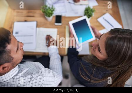 Des idées qui se rebondissent les unes sur les autres. Prise de vue en grand angle de deux collègues qui ont une discussion pendant leur travail au bureau. Banque D'Images