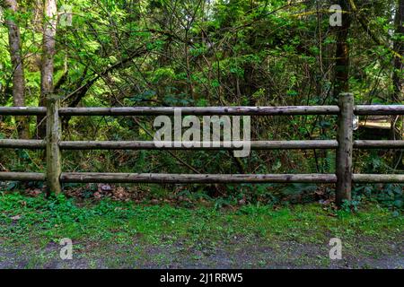 Clôture de rail à trois niveaux vieille au milieu d'un parc plat faisant face à des proportions égales. Banque D'Images