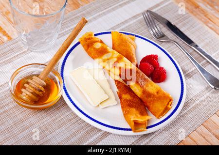 Crêpes au miel, framboises et tranches de fromage Banque D'Images