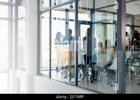 Tout commence dans la salle de réunion. Photo d'une réunion d'affaires dans une salle de réunion vitrée. Banque D'Images