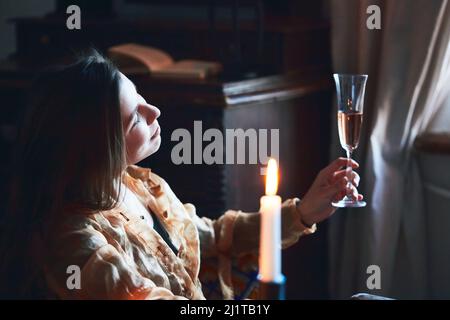 Une belle femme boit du champagne à l'hôtel. Se détend et aime la vie. Photo verticale. Banque D'Images