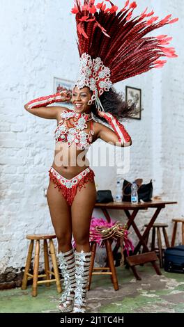 Mettre son costume est de l'amener dans l'humeur. Photo rognée d'un magnifique danseur de samba se préparer à un spectacle pendant le carnaval. Banque D'Images