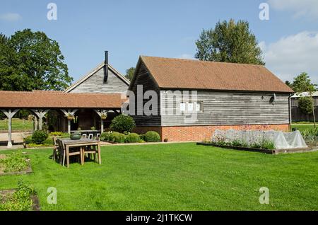 Salle à manger extérieure sur une pelouse bien entretenue entourée de lits de légumes à l'école de cuisine de l'Honesty Kitchen à North Sydmonton, Hampshire sur un soleil, s Banque D'Images