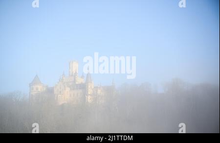 Pattensen, Allemagne. 28th mars 2022. De denses nuages de brouillard survoguez le château de Marienburg dans la région de Hanovre en début de matinée au lever du soleil. Credit: Julian Stratenschulte/dpa/Alay Live News Banque D'Images