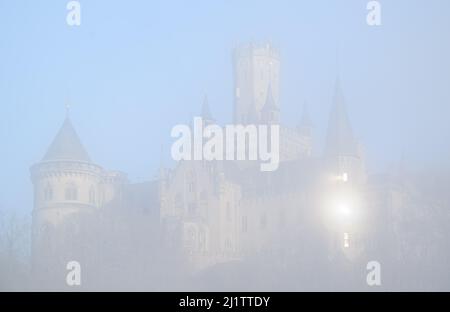 Pattensen, Allemagne. 28th mars 2022. De denses nuages de brouillard survoguez le château de Marienburg dans la région de Hanovre en début de matinée au lever du soleil. Credit: Julian Stratenschulte/dpa/Alay Live News Banque D'Images