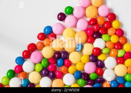 Bonbons colorés dans le bol, bonbons toutes couleurs, fond blanc Banque D'Images