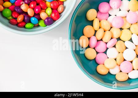 Bonbons colorés dans le bol, bonbons toutes couleurs, fond blanc Banque D'Images