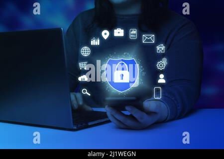 Femme vérifiant un smartphone avec une interface de sécurité numérique. Internet des objets. Concept de cybersécurité. Icône de protection avec un symbole de verrouillage. Banque D'Images