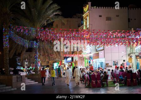 Muscat,Oman - Mars 05,2022 : vues de nuit sur les rues, les magasins et les habitants de la région dans diverses activités dans le marché de la vieille ville de Mutrah. Banque D'Images