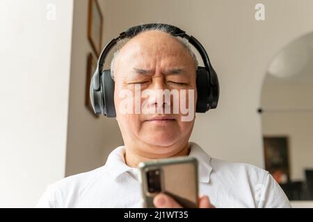 Un homme qui écoute de la musique en ligne avec un casque. Banque D'Images