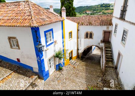 Vue sur une belle rue à Óbidos avec une architecture traditionnelle et des couleurs Banque D'Images