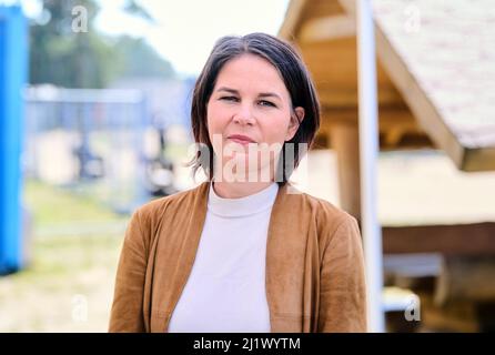 28 mars 2022, Brandebourg, Eisenhüttenstadt: Annalena Baerbock (Bündnis 90/ Die Grünen), Ministre fédéral des Affaires étrangères, se trouve devant les conteneurs du Centre d'accueil initial des demandeurs d'asile d'Eisenhüttenstadt. Photo: Annette Riedl/dpa Banque D'Images