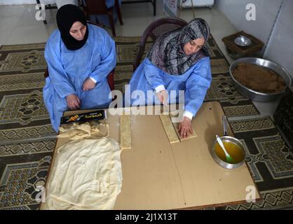 Gaza. 28th mars 2022. Les Palestiniens préparent de la nourriture qui sera vendue pendant le mois Saint islamique du Ramadan dans un magasin de nourriture de la ville de Khan Younis, dans la bande de Gaza, le 28 mars 2022. Crédit: Emad Drimly/Xinhua/Alamy Live News Banque D'Images